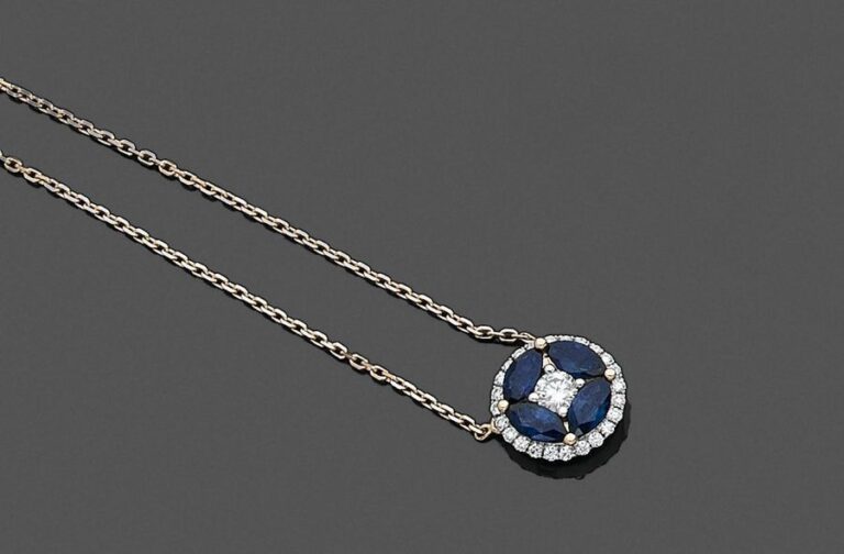 •PENDENTIF circulaire et sa chaînette or jaune et gris (750‰) serti de diamants taille brillant, et quatre saphirs taille navett