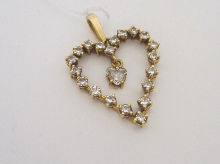 PENDENTIF «coeur» en or jaune (750 millièmes) ajouré, serti de diamants taille brillant et retenant en pampille un diamant taillé en coeu
