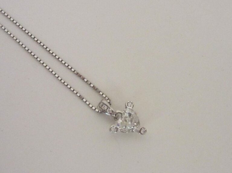 PENDENTIF «coeur», et sa chaînette, en or gris (750 millièmes) serti d'un diamant de forme coeu