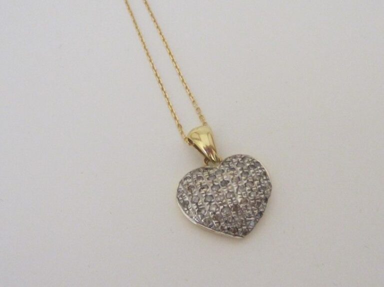 PENDENTIF «coeur», et sa chaînette, en or jaune et or gris (750 millièmes) ciselé serti de diamants taille brillan