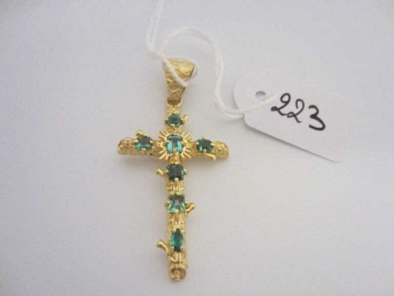 PENDENTIF «croix» en or jaune (750 millièmes) ciselé et serti d'émeraudes de taille différente