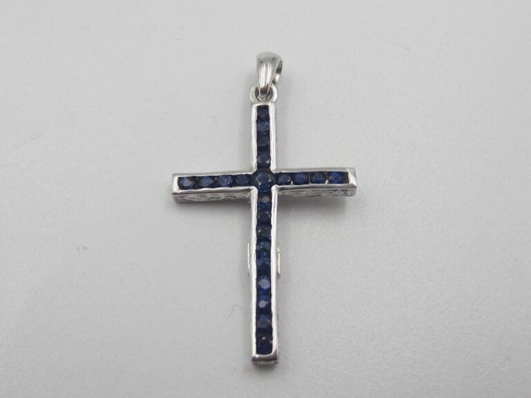 PENDENTIF «croix réversible» en or gris (750 millièmes) ciselé, serti de saphirs ronds d'un côté, et diamants taille brillant de l'autr