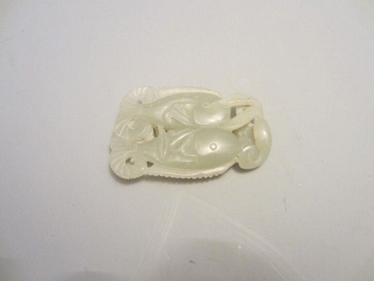 PENDENTIF EN JADE AUX DEUX CARPES ET LINGZHI Chine, époque XXe siècle Note: l'association de deux poissons - en l'espèce, des carpes - formule un voeu de marriage heureu