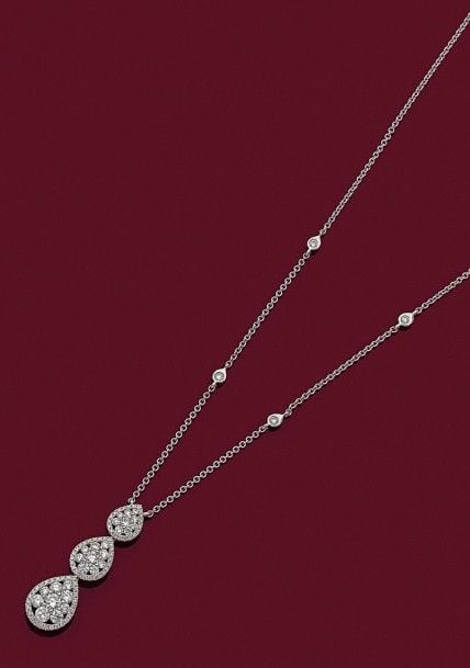 PENDENTIF en or gris (750 millièmes) composé d'une suite de trois gouttes en chute, ajourées serties de diamants taille brillan