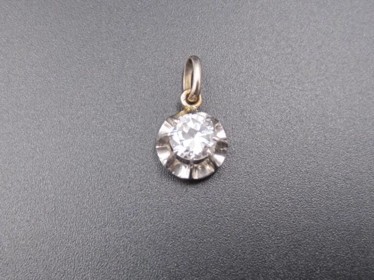 PENDENTIF en or gris (750 millièmes) serti d'un diamant , sur un motif juponn