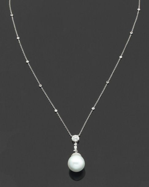 PENDENTIF en or gris articulé serti de diamants de taille brillant, princesse et navettes, retenant une importante perle de culture blanch