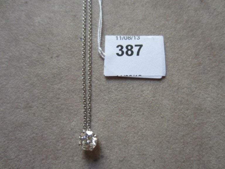 PENDENTIF en or gris serti d'un diamant taille brillant, et sa chaînette en or gri