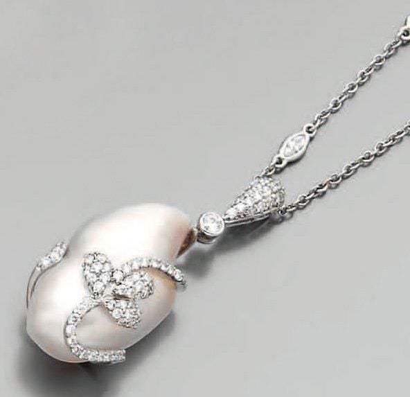PENDENTIF et sa chaînette, en or gris serti d'une perle de culture baroque rehaussée de diamant