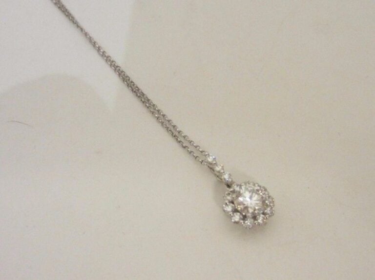 PENDENTIF « fleurette » en or gris (750 millièmes) serti de diamants taille brillant dont un, au centre, plus importan