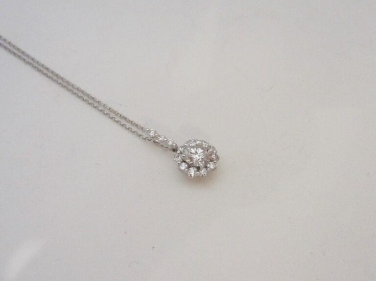PENDENTIF « fleurette » en or gris (750 millièmes) serti de diamants taille brillant dont un, au centre, plus importan