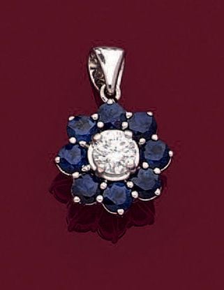PENDENTIF «fleurette», et sa chaînette, en or gris (750 millièmes) serti d'un diamant taille brillant entouré de saphirs rond