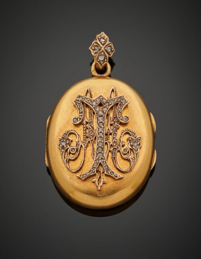PENDENTIF ovale porte-photo, ouvrant à charnières en or jaune (750‰) flanqué d'…