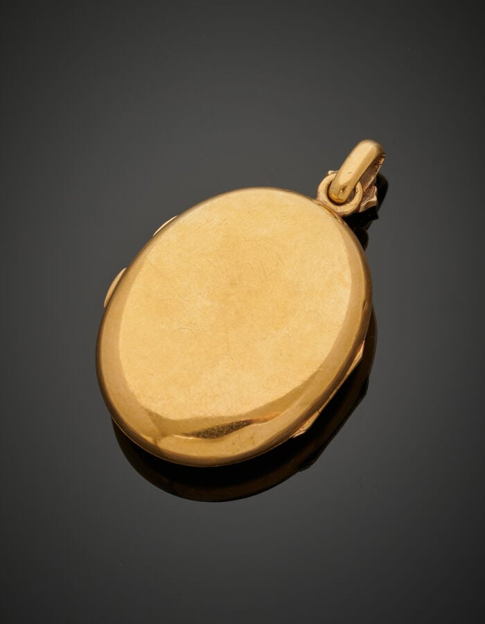 PENDENTIF ovale porte-photo, ouvrant à charnières en or jaune (750‰) flanqué d'…