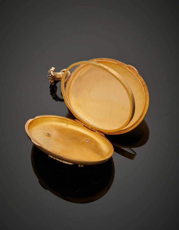 PENDENTIF ovale porte-photo, ouvrant à charnières en or jaune (750‰) flanqué d'…