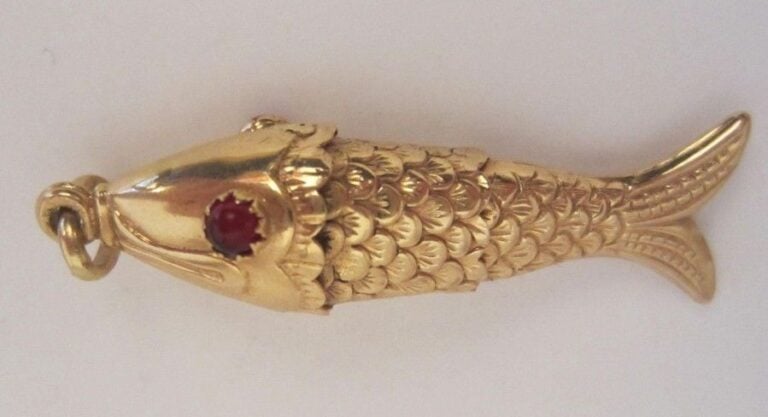 Pendentif "Poisson" articulé en or jaune (minimum 800 millièmes), l'oeil incrusté d'une pierre roug