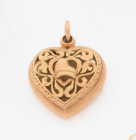 •PENDENTIF porte souvenir «cœur» en or jaune (750‰) ajouré et ciselé de volutes et un «bonnet