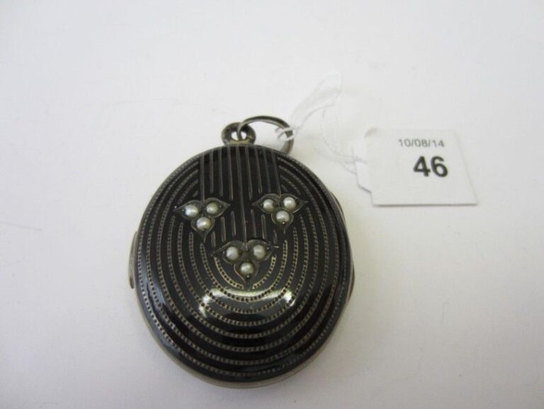 PENDENTIF «porte souvenir» ovale en argent émaillé de noir, guilloché, pointillé et serti de neuf demi-perle