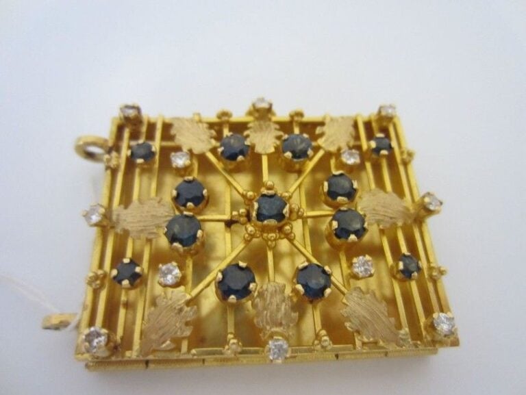PENDENTIF rectangulaire ouvrant, en or jaune (750 millièmes) ajouré à motifs de «rose des vents» serti de saphirs et brillant