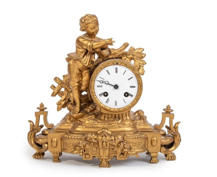 Pendule en bronze doré et ciselé à décor d'un enfant sur un tertre à branchage feuillag
