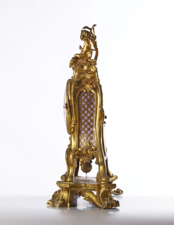 PENDULE - En bronze doré, sculpté et ciselé à décor d'amour et aux attributs de…
