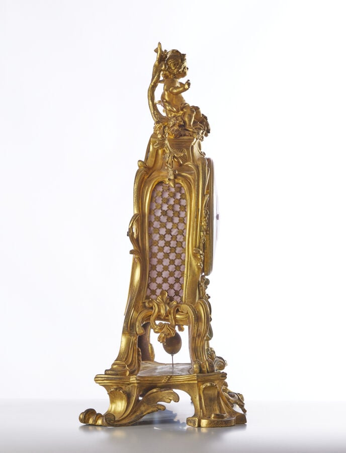 PENDULE - En bronze doré, sculpté et ciselé à décor d'amour et aux attributs de…
