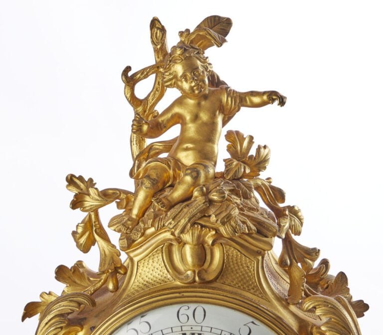 PENDULE - En bronze doré, sculpté et ciselé à décor d'amour et aux attributs de…