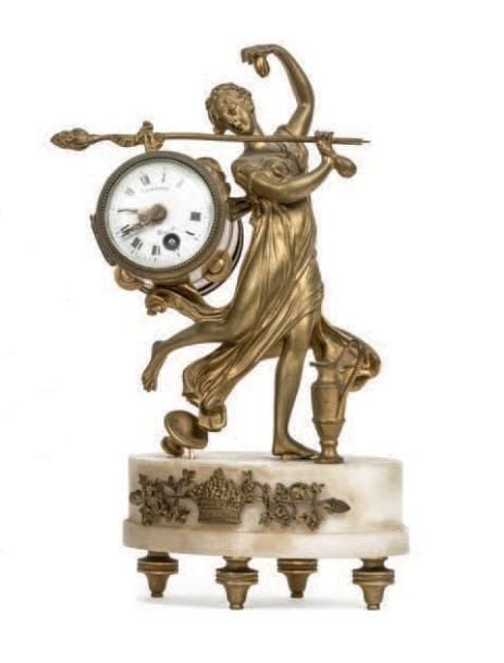 Pendule en bronze doré stylisant une femme aux instruments de musiqu
