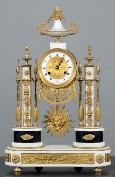 Pendule portique, en marbre blanc, marbre noir et bronze ciselé et doré, à décor à l'amortissement d'un vase chargé de fleurs et de fruit