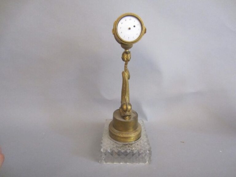 Pendulette sur Dauphins en bronze doré ; socle en cristal XIXe