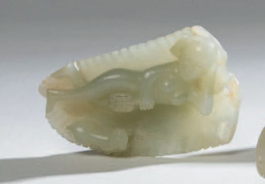 Petit sujet en jade céladon représentant une femme allongée sur une feuille de palmie
