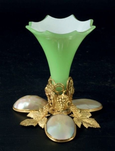 Petit vase cornet à bord dentelé en opaline verte doublée sur émail blanc; pied à trois motifs en nacre sertis dans une monture en pomponne doré à motif de pampres de vign