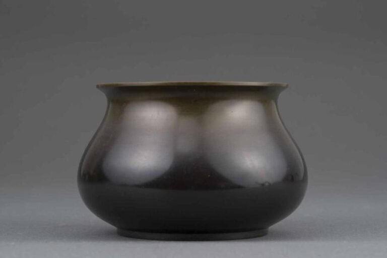PETIT VASE EN BRONZE A PATINE MARRON Japon, Epoque XXe siècle A pied annulaire plat, panse compressée et lèvre recourbé