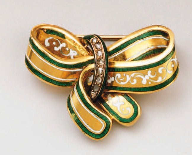 Petite broche « noeud » en or jaune, gravée émaillée blanc et vert et sertie d'une ligne de diamants taillés en rose