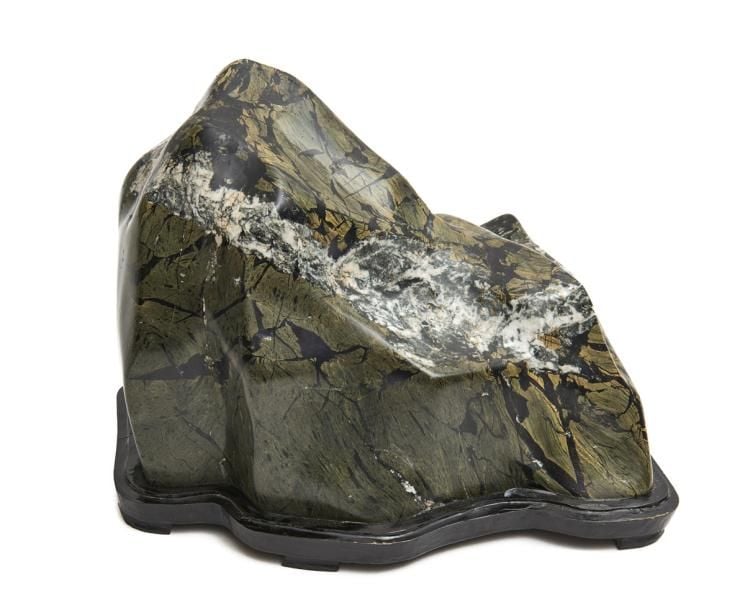 Pierre-paysage suiseki en forme de montagne de couleur gris-vert sur un socle de bois et avec une bande de calcite de couleur blanche donnant ?l'effet d'une couverture de neig