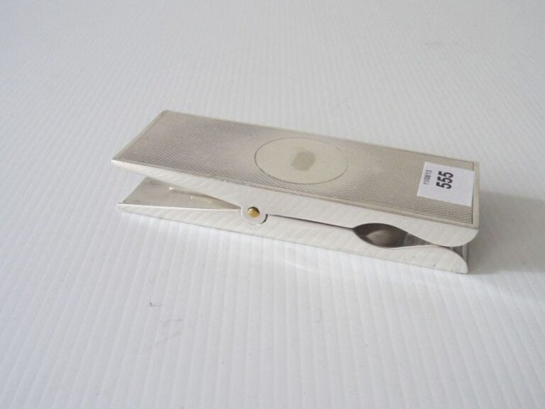 PINCE À COURRIER en argent figurant une pince à linge, le dessus guilloché à médaillon central liss