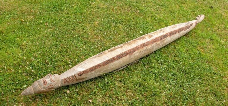 Pirogue en bois évidé et sculpté à décor de têtes aux extrémités et frises de S incisées polychrome