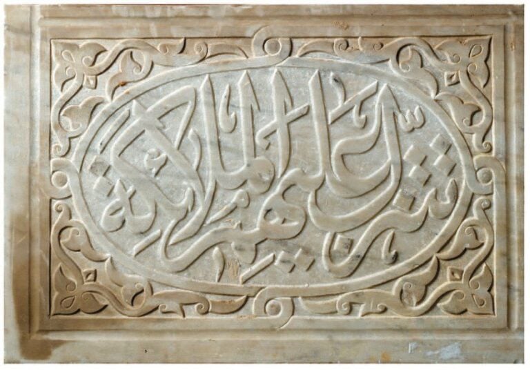 PLAQUE DE MARBRE Plaque rectangulaire en marbre, sculptée d'une inscription en relief dans un large médaillon ovale flanqué de rinceaux à fleurons dans les écoinçon