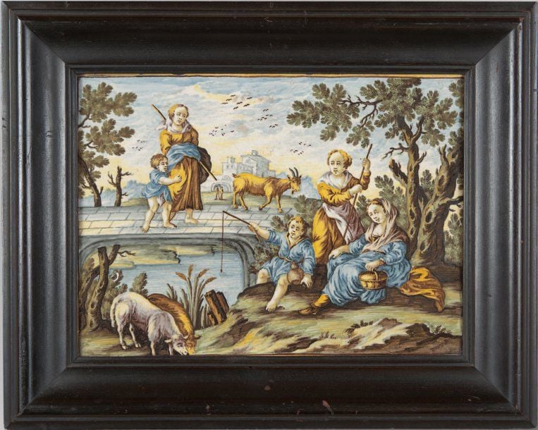 Plaque rectangulaire ornée d'un décor polychrome figurant une scène champêtre composée de bergères et d'un enfant pêchant dans une rivière au premier plan et d'une mère et son enfant marchant sur un pon