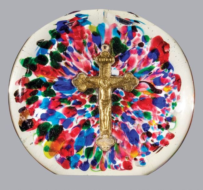 Plaque ronde à bord taillé à facettes ornée en inclusion d'une croix en métal doré sur fond jaspé polychrom