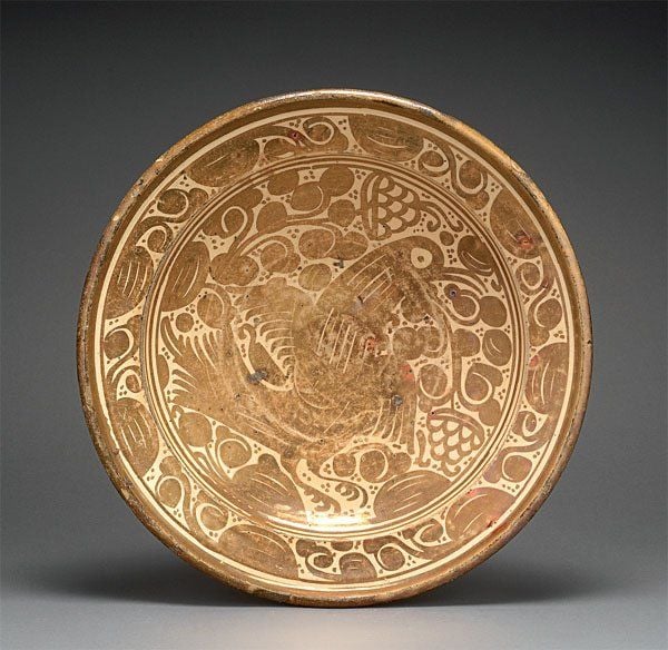 PLAT À L'OISEAU Grand plat creux à marli incliné, décoré en lustre métallique brun d'un oiseau sur fond de motifs feuillagé