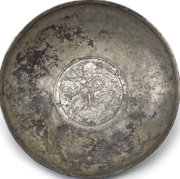 Plat circulaire sur piédouche gravé d'un roi cavalier affrontant à la lance un lion dress