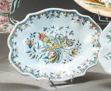 Plat creux de mariage, de forme chantournée à ruche décor polychrome dit «au carquois» figurant deux colombes se becquetant posées sur deux carquois garnis entrecroisés sur fond de tiges fleuries avec coquill