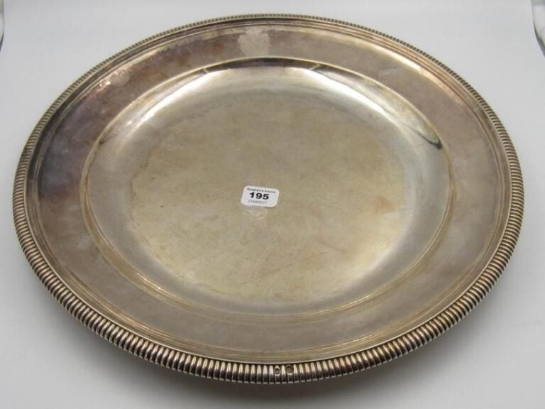 Plat en argent uni (950 ‰) à bordure godronnée; le marli gravé d'armoiries sous couronne