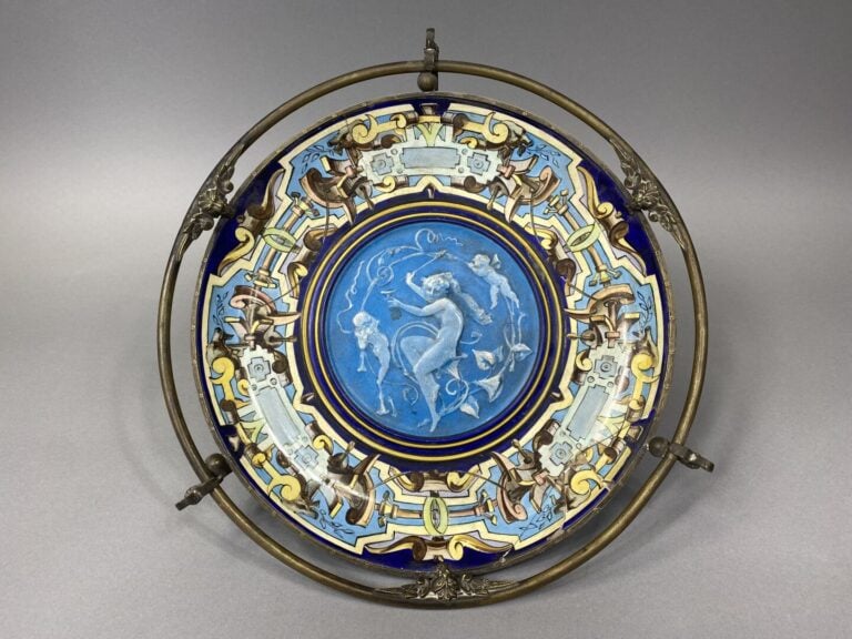 Plat en céramique polychrome à décor d'une jeune fille et de deux angelots dans…