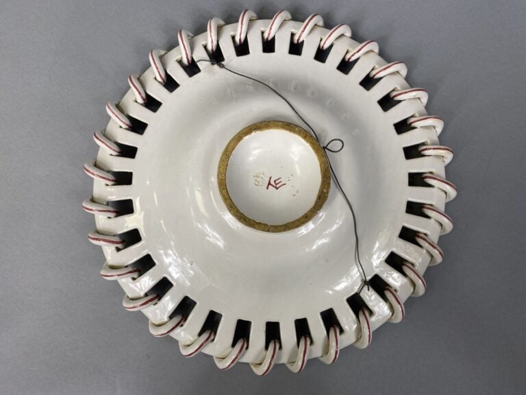 Plat en faïence émaillée à décor de motifs floraux, l'aile ajourée - Marque au…