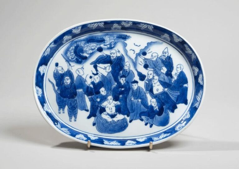 Plat en porcelaine à décor en bleu sous couverte des dix-huit luohan, au pochoi