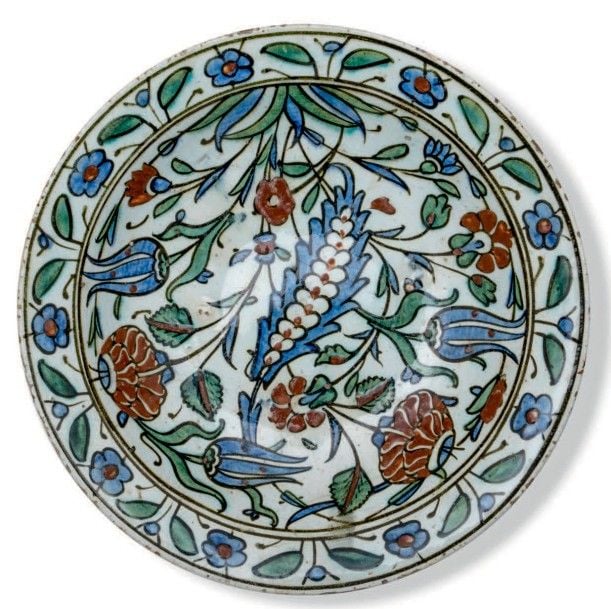 Plat Iznik à décor de feuille Saz perlée au marli fleuri