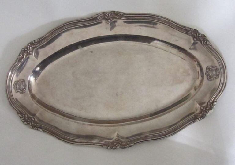 PLAT LONG en métal doublé à filets forts et agrafes feuillagées et décor d'armoiries en relie