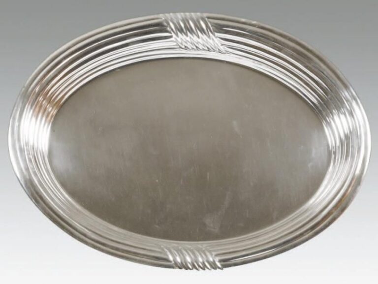Plat ovale en argent, la bordure constituée de larges cannelures entrecoupée de deux bandes de cannelures plus petite