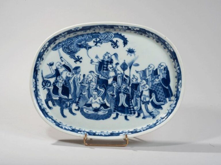 Plat ovale en porcelaine à décor en bleu sous couverte des dix-huit luohan réuni